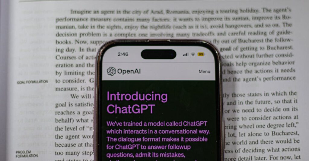 Smartphone showing OpenAI ChatGPT in focus, on top of an open book, highlighting technology and learning.